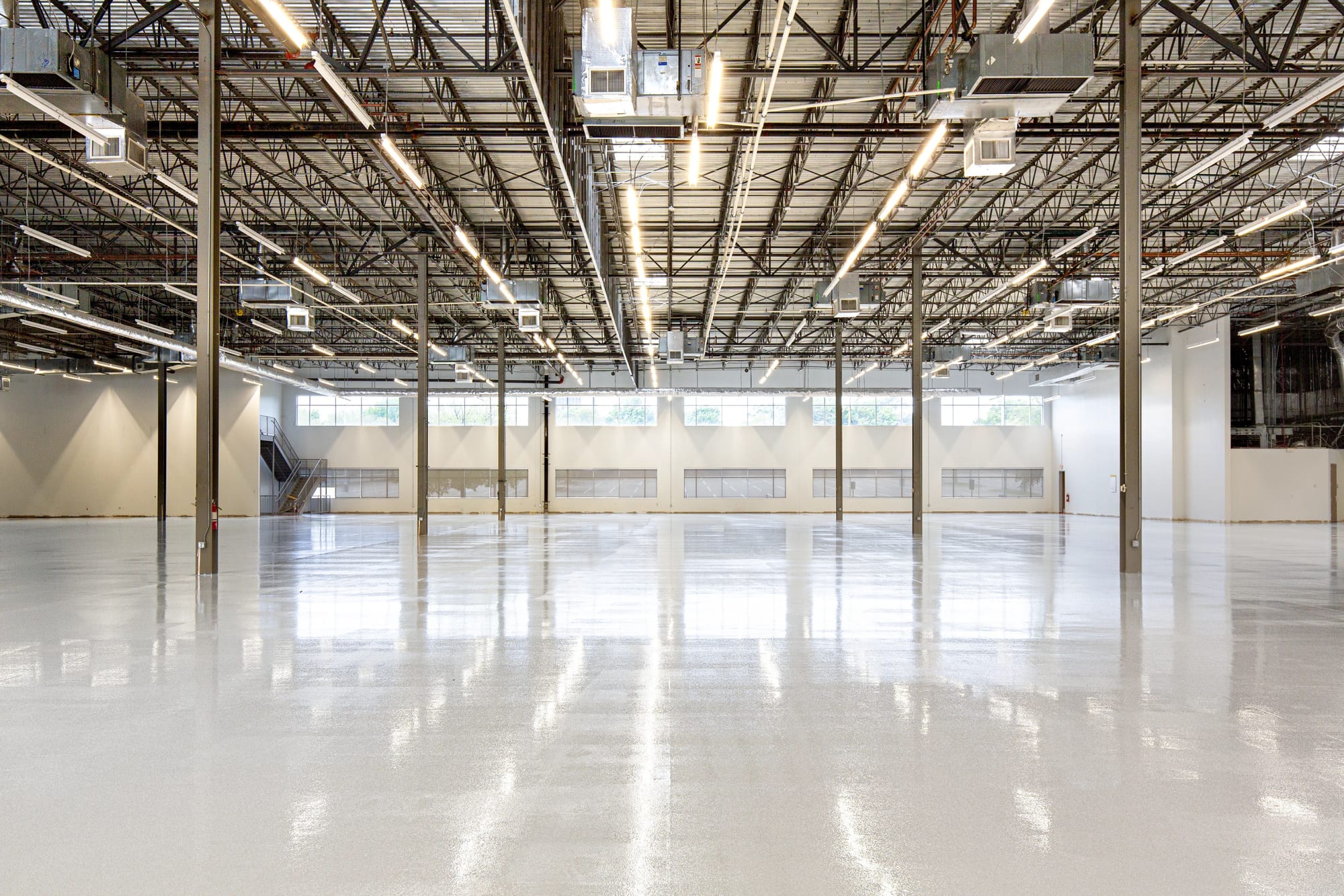 Vom Estrichleger versiegelter Industrieboden spiegelt glänzend in einer großen Lagerhalle